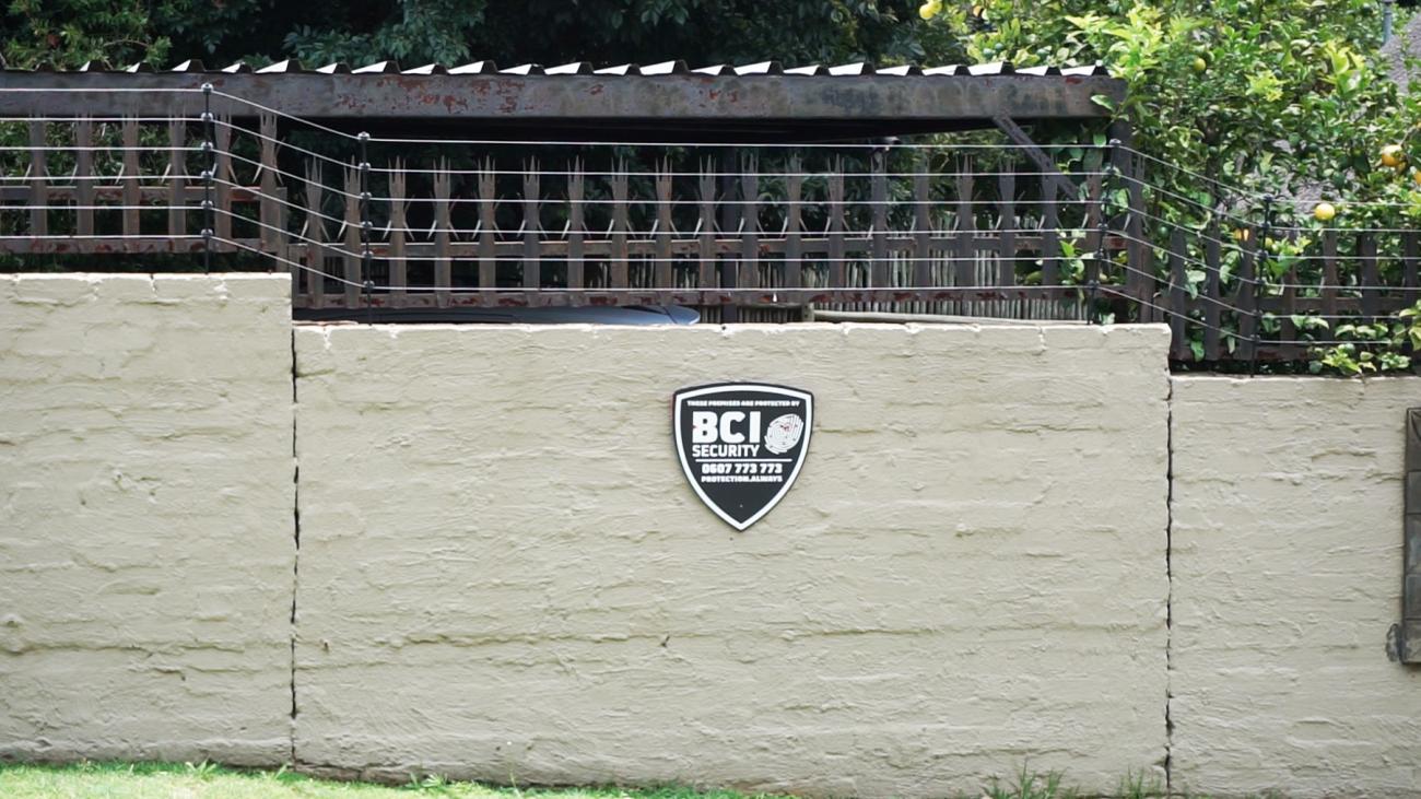 Photograph by Anna Boldt and Mathias Weinfurter of a wall with wired fence on top, taken while in residency at NIROX Foundation, South Africa.