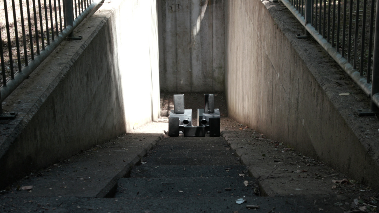 A pair of speakers placed on a concrete staircase going down